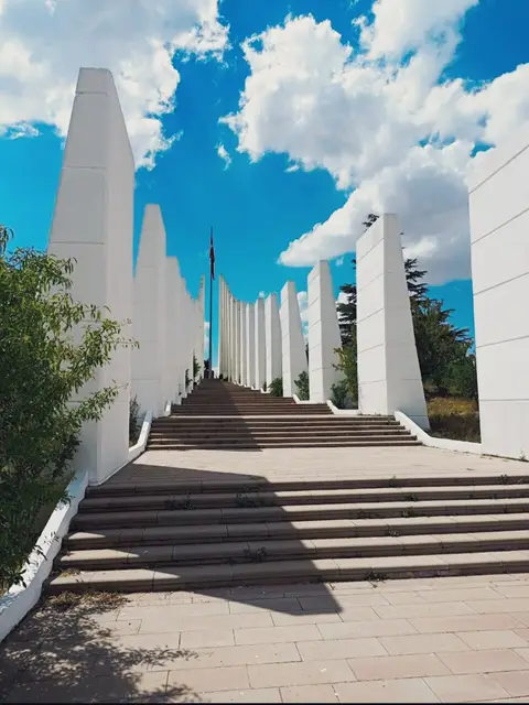 Sakarya Meydan Muharebesi Tarihi Milli Parkı'nda mavi gökyüzü altında yükselen beyaz sütunlu şehitlik anıtı ve basamakları