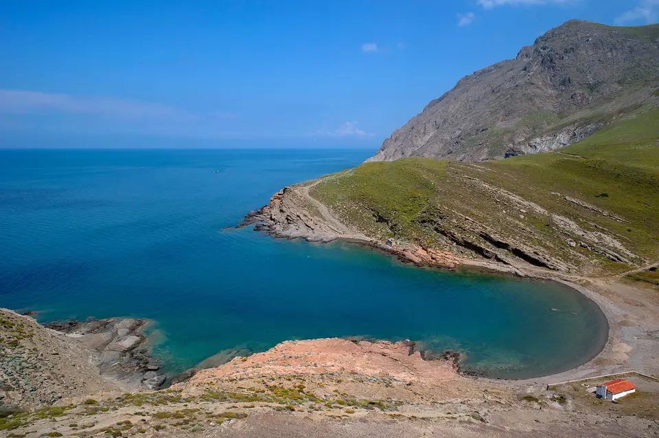 Yeşil tepelerin arasında turkuaz suyu ve kumsalıyla küçük bir koy