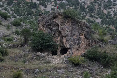 Obruk Şelalesi Tabiat Parkı'nda çalılarla çevrili, oyuklu kaya kütlesi