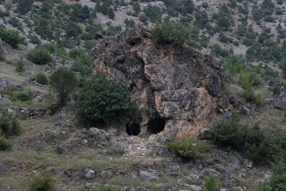 Obruk Şelalesi Tabiat Parkı'nda çalılarla çevrili, oyuklu kaya kütlesi
