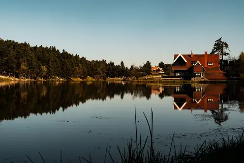 Bolu Gölcük'te göl kıyısındaki ahşap köşkün durgun suya yansıması