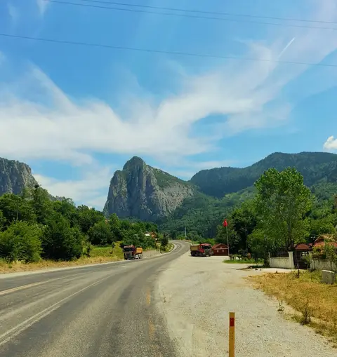 Ersizlerdere Kanyonu Tabiat Parkı'nda yeşil ormanlı yamaçlardan yükselen sivri kaya kuleleri ve kanyona uzanan yol