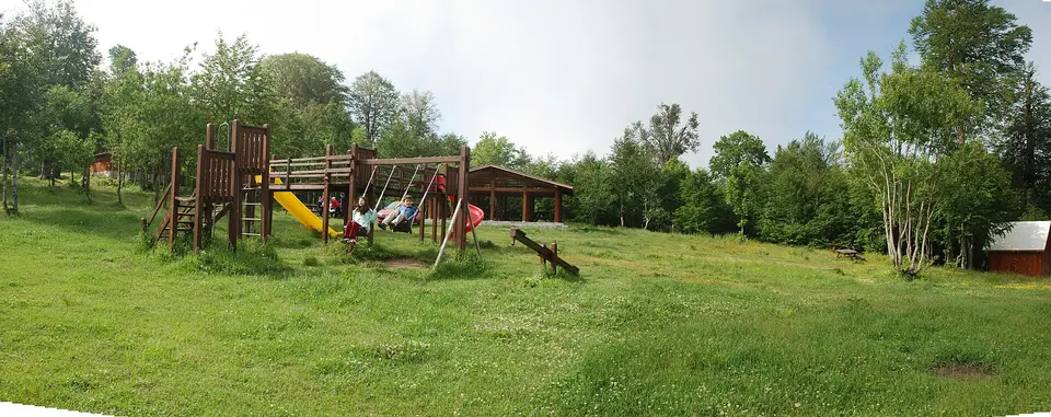 Kuzuyayla Tabiat Parkı'nda çayır üzerindeki çocuk oyun alanı ve ağaçlar