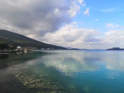 Güvercinlik Tabiat Parkı çevresinde ormanlı yamaçların yansıdığı durgun koy