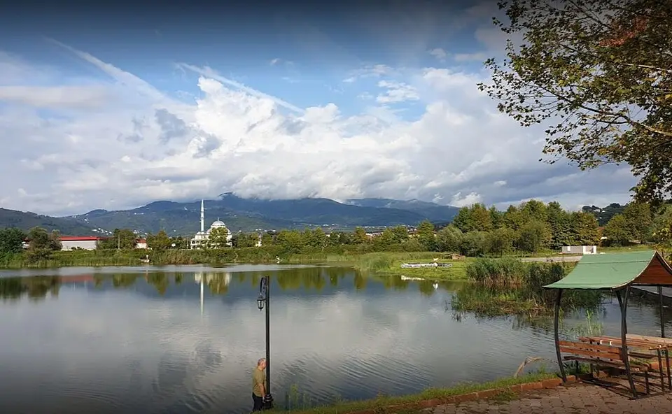Kuzuluk Tabiat Parkı'nda göl kıyısında ahşap çardak, uzakta ormanlı dağlar